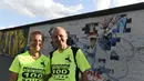 Martina Schliep (kiri) dan Gaston Pruefer berpose di sisi timur Tembok Berlin, Jerman, (11/8/2014). (AFP PHOTO/Tobias Schwarz)