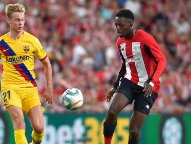 Striker Athletic Bilbao, Inaki Williams (kanan) membawa bola dari kejaran gelandang Barcelona, Frenkie de Jong  selama pertandingan perdana La Liga Spanyol di Stadion San Mames, Sabtu (17/8/2019). Bilbao menang tipis atas Barcelona dengan skor 1-0. (AFP Photo/Ander Gillenea)