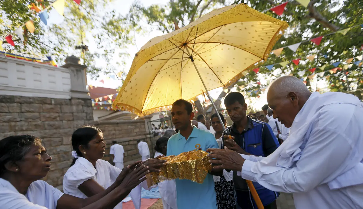 Umat Buddha berdoa di depan Sri Maha Bodhi (the sacred Bo tree of Anuradhapura) pada hari Poya untuk menandai kunjungan kedua Buddha ke Sri Lanka (21/4). Hari Poya dijadikan hari libur Nasional bagi warga Sri Lanka. (REUTERS/Dinuka Liyanawatte)