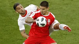Striker Serbia, Aleksandar Mitrovic, berebut bola dengan bek Swiss, Ricardo Rodriguez, pada laga grup E Piala Dunia di Stadion Kaliningrad, Kaliningrad, Jumat (22/6/2018). Swiss menang 2-1 atas Serbia. (AP/Antonio Calanni)