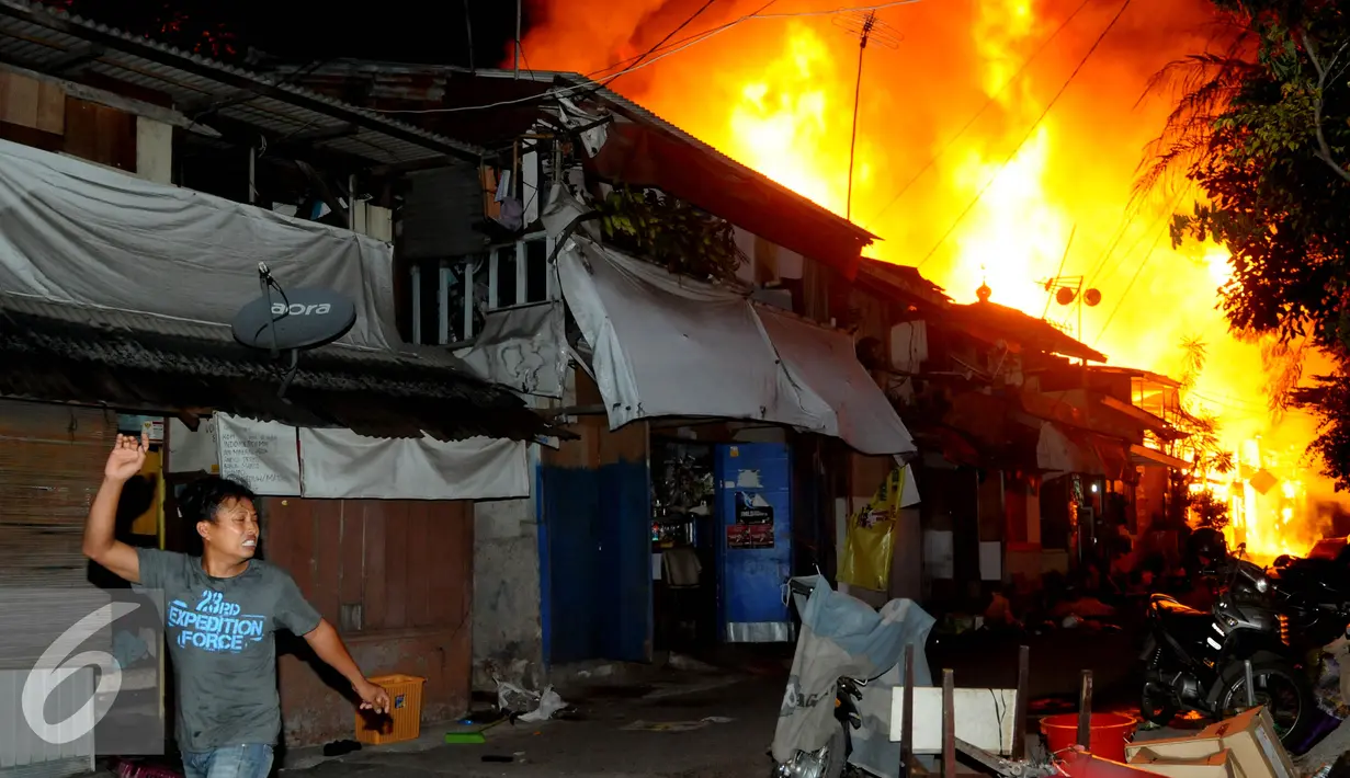 Warga menyelamatkan diri dari kebakaran yang terjadi di belakang Senayan City, Jakarta, Minggu (3/7) dini hari. Api diduga berasal dari korsleting listrik di salah satu rumah yang saat itu dalam keadaan kosong. (Liputan6.com/Helmi Afandi)