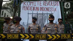 Polisi berjaga saat buruh, mahasiswa dan pelajar berunjuk rasa di depan gedung Kementerian Pendidikan dan Kebudayaan, Jakarta, Selasa (17/11/2020). Selain menuntut pencabutan UU Ciptaker, mereka juga meminta pemerintah menggratiskan biaya pendidikan selama pandemi Covid-19. (merdeka.com/Imam Buhori)