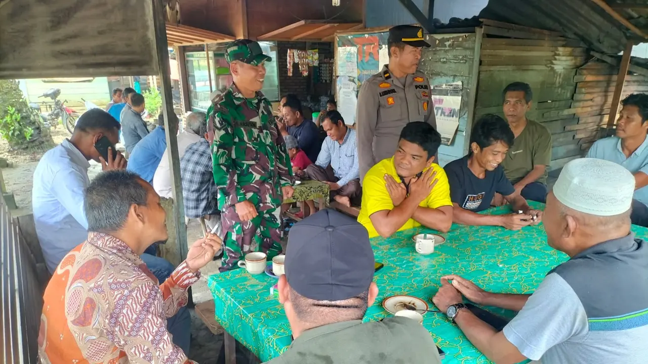 Personel Polres Rokan Hulu dan TNI bercengkrama di sebuah warung sosialisasi Pilkada damai.