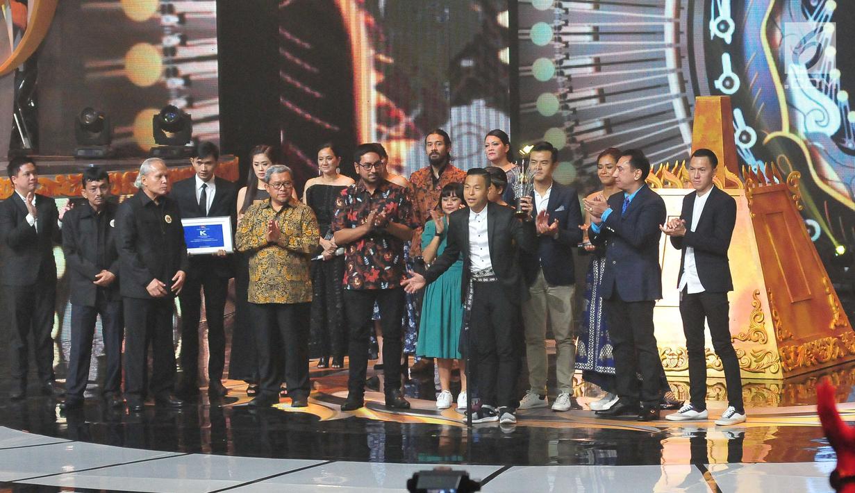 Ernest Prakasa mengangkat piala usai film Bioskop Cek Toko Sebelah dinobatkan menjadi Film Terpuji dalam ajang Festival Film Bandung 2017 di studio 6 Emtek, Jakarta (22/10). (Liputan6.com/Helmi Afandi)
