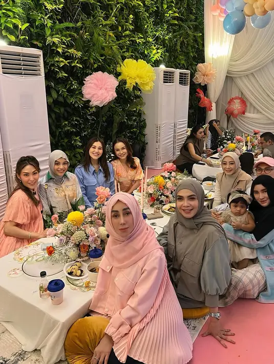 Aurel memilih tampilan yang simple namun tetap berkelas dengan setelan kemeja panjang satin bermotif warna pastel. Ia memadukannya dengan pashmina kaos warna light grey, menciptakan gaya effortless yang cocok untuk acara keluarga. [@rieta_amilia/@syahnazs/@aaliyah.massaid].