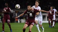 Duel antara De Silvesri dan Piatek pada laga lanjutan Serie A yang berlangsung di Stadion Turin, Torino, Senin (30/4). AC Milan kalah 0-2 kontra Torino. (AFP/Marco Bertorello)