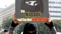 Anggota komunitas  Niqab Squad menunjukan poster saat melakukan Challenge kepada pengunjung CFD untuk mengenakan Niqab di kawasan Bundaran HI, Jakarta, Minggu (10/9). (Liputan6.com/Johan Tallo)
