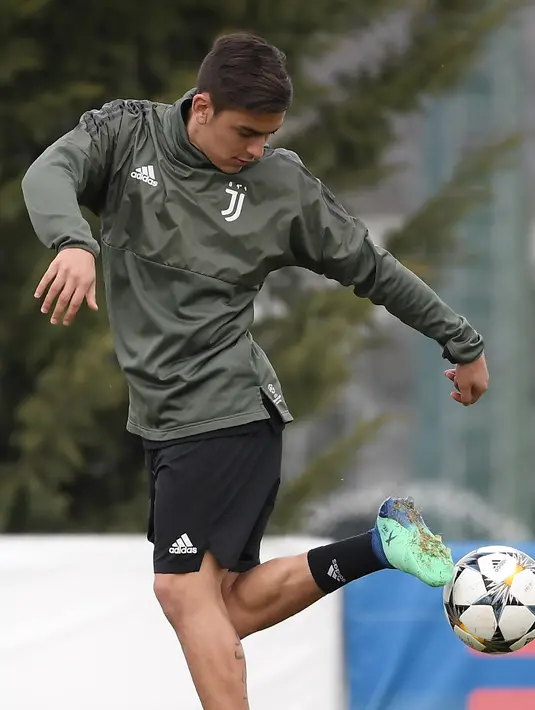 Penyerang Juventus, Paulo Dybala berusaha mengontrol bola saat mengikuti sesi latihan jelang menghadapi Real Madrid pada leg pertama babak perempatfinal Liga Champions di pusat pelatihan Juventus di Vinovo (2/4). (AFP Photo/Marco Bertorello)