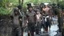 Warga berjalan menyusuri hutan mangrove saat mengikuti tradisi mandi lumpur atau mebuug-buugan di Desa Kedonganan, Denpasar, Bali, Jumat (8/3). Tradisi ini bermakna membersihkan diri dari dosa-dosa yang setahun belakangan dilakukan. (Sonny Tumbelaka/AFP)