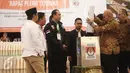 Petugas memasukan berkas kedalam kotak usai menggelar rekapitulasi penghitungan sura tingkat provinsi Pilkada DKI Jakarta di Grand Sahid, Jakarta, Minggu (26/2). (Liputan.com/Faizal Fanani)