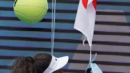 Petenis Jepang Naomi Osaka menandatangani topi yang disodorkan penonton usai mengalahkan petenis Republik Ceko Marie Bouzkova pada Australia Terbuka di Melbourne, Australia, Senin (20/1/2020). Penonton menyodorkan topi, bendera, hingga bola untuk ditandatangani Naomi. (AP Photo/Lee Jin-man)