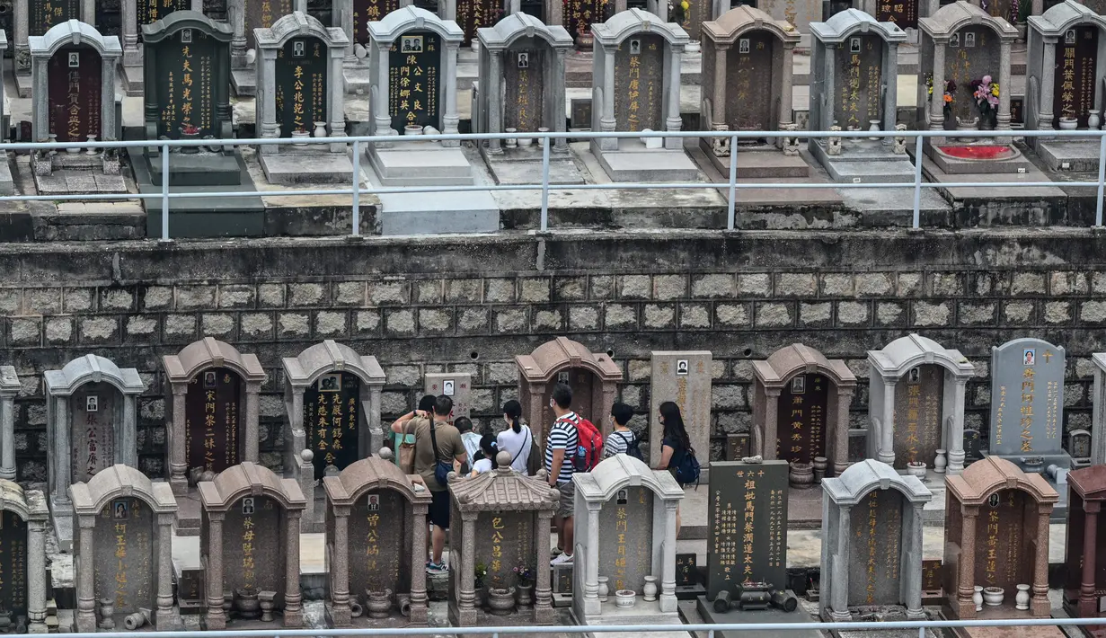 Orang-orang mengunjungi Pemakaman China Cape Collinson untuk memberi penghormatan kepada orang tercinta yang telah meninggal di dekat Chai Wan, Hong Kong, 5 April 2021. Kegiatan ini untuk menandai Festival Ching Ming yang juga dikenal sebagai pembersihan makam. (Peter PARKS/AFP)