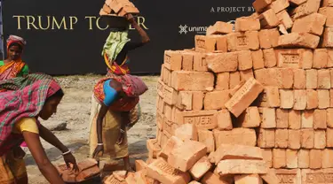 Buruh wanita India mengangkat batu bata untuk pembangunan konstruksi Trump Tower atau Menara Trump di Kolkata, India (20/2). (AFP/ Dibyangshu Sarkar)