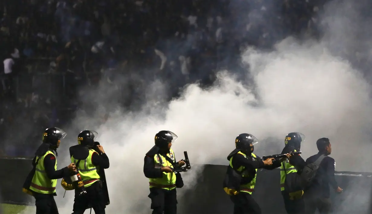 Polisi menembakkan gas air mata saat kerusuhan pada pertandingan sepak bola antara Arema Vs Persebaya di Stadion Kanjuruhan, Malang, Jawa Timur, 1 Oktober 2022. Menurut Kapolda Jawa Timur Irjen Pol Nico Afinta, hingga saat ini terdapat kurang lebih 180 orang yang masih menjalani perawatan di sejumlah rumah sakit tersebut. (AP Photo/Yudha Prabowo)