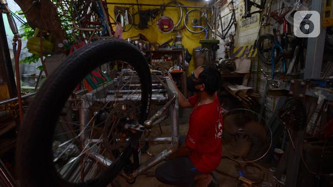 Pemilik workshop Alam Project, Alam menyelesaikan pembuatan sepeda multiguna atau kargo di bengkelnya kawasan Tangerang Selatan, Sabtu (10/7/2020). Pada masa Pandemi Covid-19, pesanan sepeda kargo meningkat seiring tingginya trend sepeda tersebut di kalangan 'goweser'. (merdeka.com/Imam Buhori)
