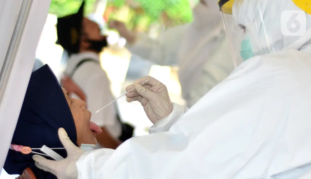 Petugas medis mengambil sampel lendir saat tes swab PCR massal di Kantor Kecamatan Pancoran Mas, Depok, Selasa (5/1/2021). Puskesmas Pancoran Mas melakukan tes Swab PCR kepada warga yang pernah memiliki riwayat kontak erat dengan pasien terkonfirmasi positif Covid-19. (merdeka.com/Arie Basuki)