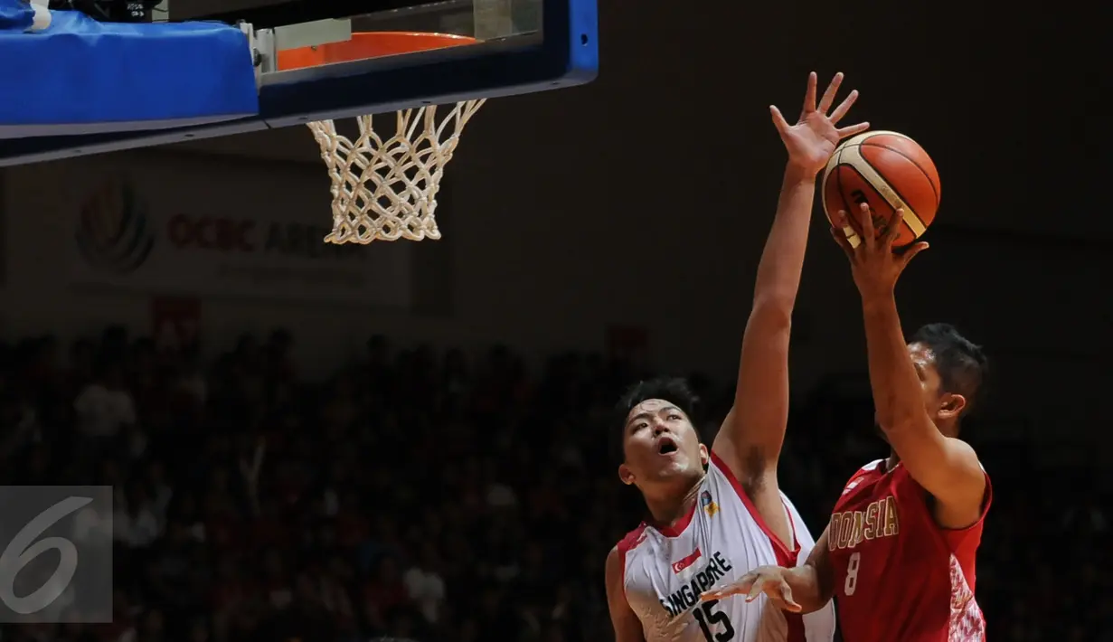 Pebasket Indonesia, A Santosa (kanan) mencoba mengecoh pemain Singapura, Russei Low di laga semifinal SEA Games ke-28 di OCBC Arena Singapore, Minggu (14/6/2015). Indonesia unggul 87-74 atas Singapura. (Liputan6.com/Helmi Fithriansyah)