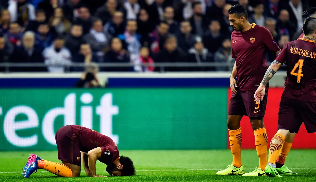 Gelandang AS Roma, Mohamed Salah (kiri) melakukan selebrasi usai mencetak gol ke gawang Lyon pada leg pertama babak 16 besar Liga Europa di Stade de Lyon, Prancis, (9/3). Lyon berhasil mengalahkan AS Roma dengan skor 4-2. (AFP Photo / Romain Lafabregue)
