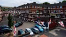 Bendera Inggris itu berjajar rapi di setiap balkon rumah, menggantung di atas lahan parkir, hingga menempel ke tembok gedung. (BENJAMIN CREMEL / AFP)