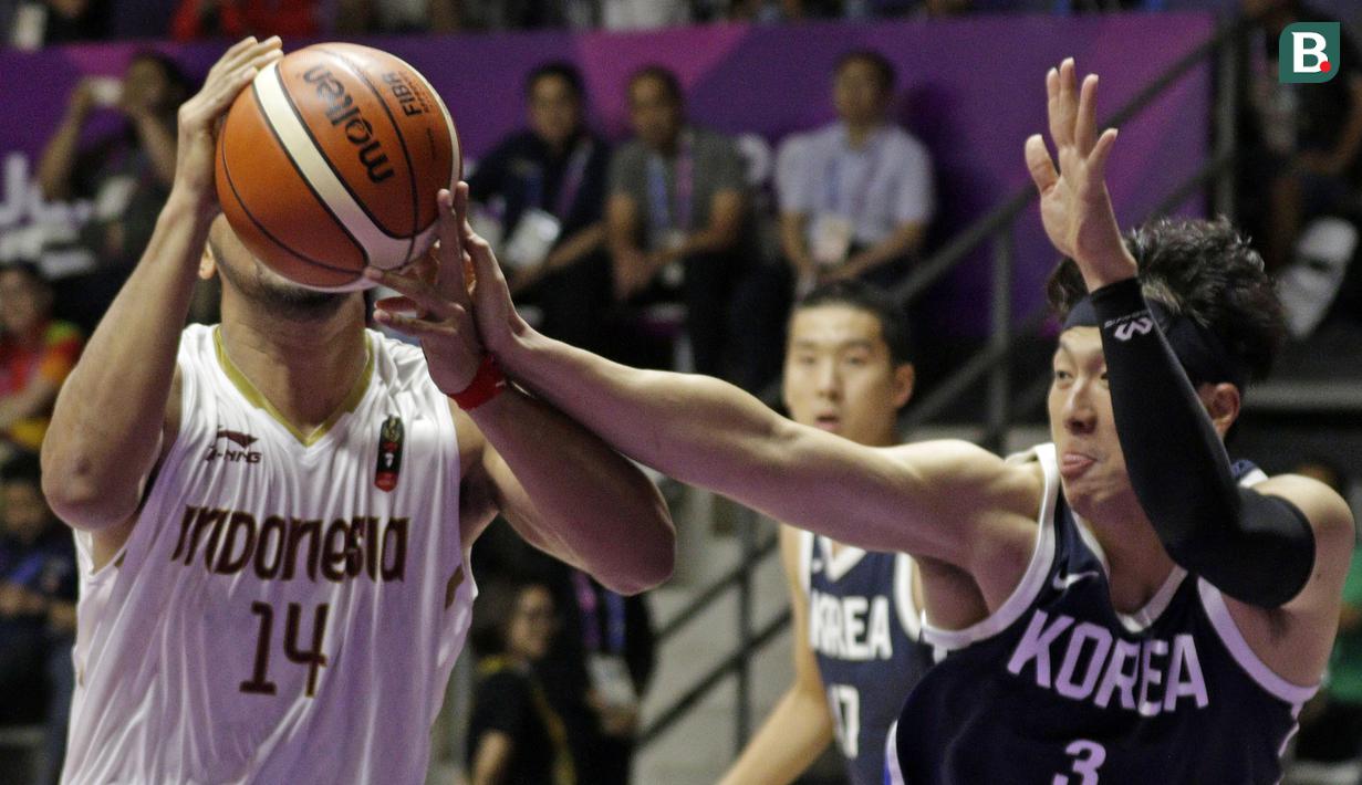 Pebasket Indonesia, Adhi Pratama Prasetyo Putra, berebut bola dengan pebasket Korea Selatan, Junghyun Lee, pada laga Asian Games 2018 di Hall Basket GBK, Selasa (14/8/2018). Indonesia takluk 65-104 dari Korsel. (Bola.com/Peksi Cahyo)