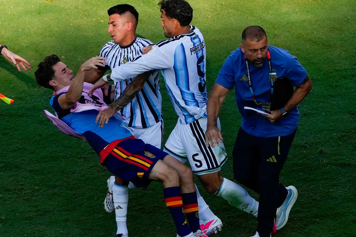 Pemain Spanyol Gavi (kiri) terjatuh saat terlibat keributan dengan pemain Argentina Leandro Paredes (5) dan Thiago Almada