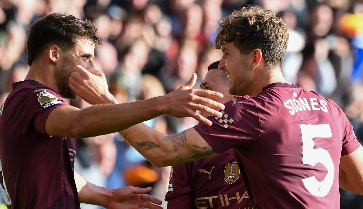 John Stones (kanan merayakan gol bersama Ruben Dias yang menjadi penentu kemenangan Manchester City atas Wolverhampton 2-1 di laga pekan ke delapan Premier League 2024/2025 di Molineux, Minggu (20/10/2024) malam WIB.