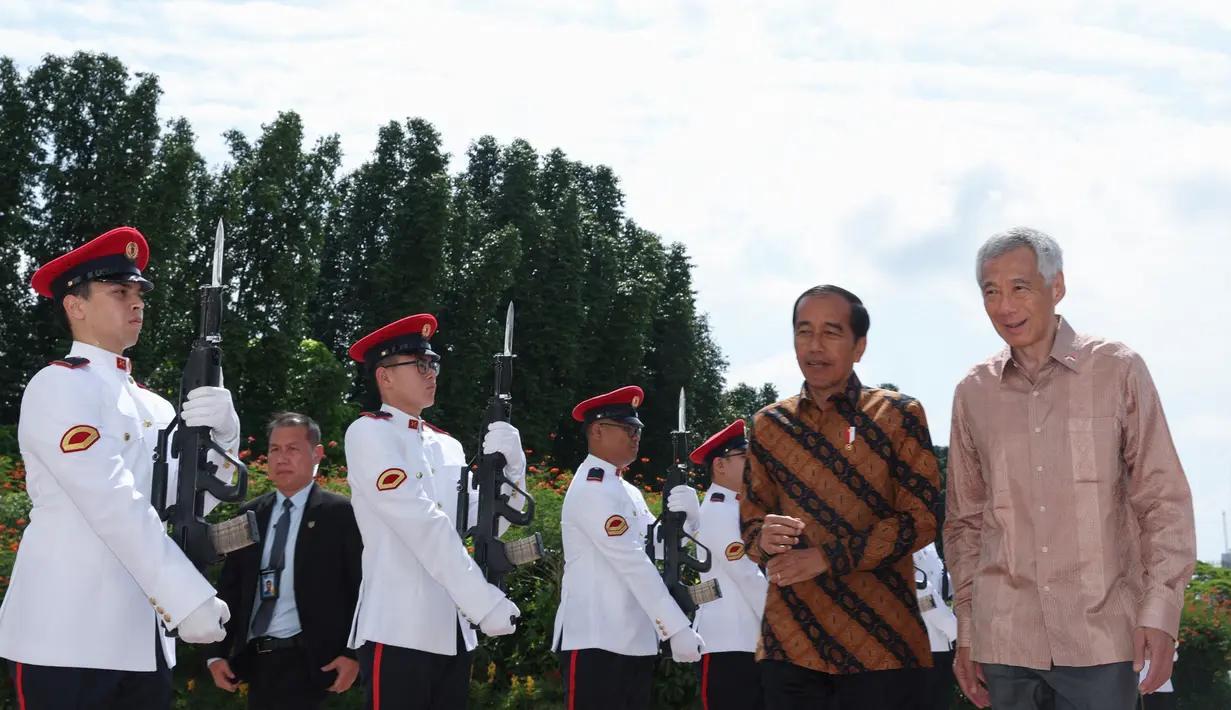 Perdana Menteri Singapura Lee Hsien Loong (kanan) menyambut Presiden Indonesia Joko Widodo atau Jokowi di Istana Kepresidenan Singapura, Singapura, Kamis (16/3/2023). (EDGAR SU/POOL/AFP)