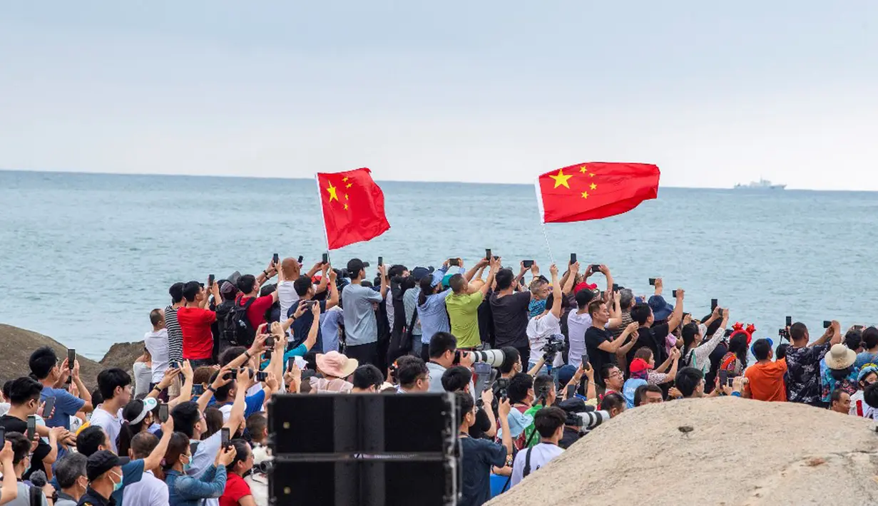 Warga menyaksikan peluncuran roket Long March 5B yang membawa modul inti stasiun luar angkasa Tianhe dari Pusat Peluncuran Luar Angkasa Wenchang di Provinsi Hainan, China, Rabu (29/4/2021). Stasiun baru akan beroperasi setidaknya selama sepuluh tahun. (STR/AFP)