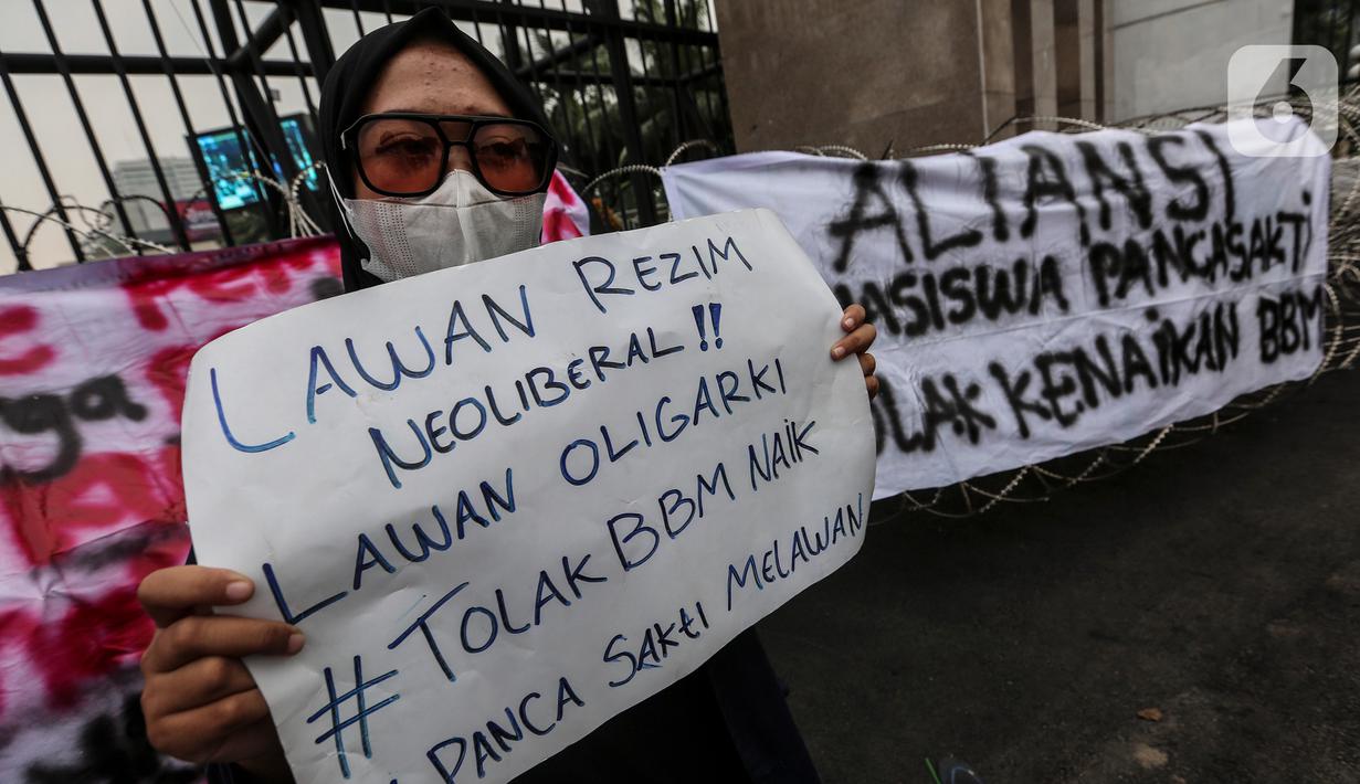 Mahasiswa membawa poster saat demo teatrikal di depan Gedung DPR/MPR RI, Jakarta Pusat, Jumat (9/9/2022). Demo tersebut untuk menolak kebijakan pemerintah menaikkan harga BBM. (Liputan6.com/Johan Tallo)