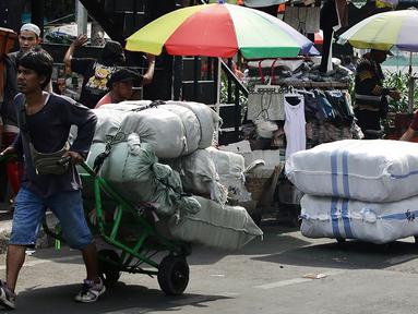 Sejumlah porter mengangkut barang di kawasan Pasar Tanah Abang, Jakarta, Senin (27/3/2023). (Liputan6.com/Johan Tallo)