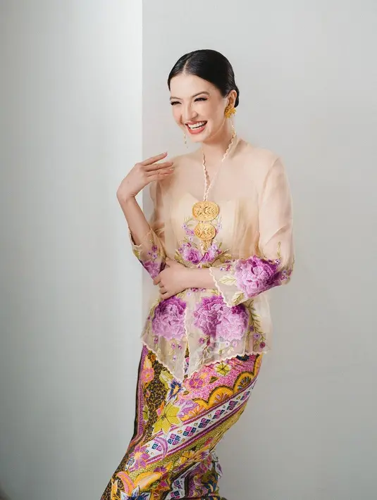 Raline Shah tampil tak kalah memesona. Ia memilih mengenakan kebaya kuning semi transparan dengan aksen bordir flora berwarna ungu, dipadu dengan kain batik bermotif dan bernuansa serasi. [Instagram/ralineshah]