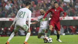 Striker Portugal, Cristiano Ronaldo, berusaha melewati pemain Aljazair pada laga uji coba di Estadio da Luz, Jumat (8/6/2018). Portugal menang 3-0 atas Aljazair. (AP/Armando Franca)