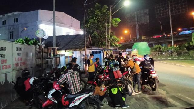 Kerumunan Pemudik Sepeda Motor Saat Beristirahat Sambil Membeli Tiket Dekat Pelabuhan Merak, Kota Cilegon, Banten. Rabu (05/05/2021). (Liputan6.com/Yandhi Deslatama).