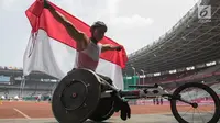 Pebalap kursi roda Indonesia, Jaenal Aripin, berselebrasi usai meraih medali perak Asian Para Games pada cabang atletik nomor balap kursi roda 200 meter T 54 di SUGBK, Jumat (12/10). Jaenal mencatatkan waktu 26,21 detik. (Bola.com/Vitalis Yogi Trisna)