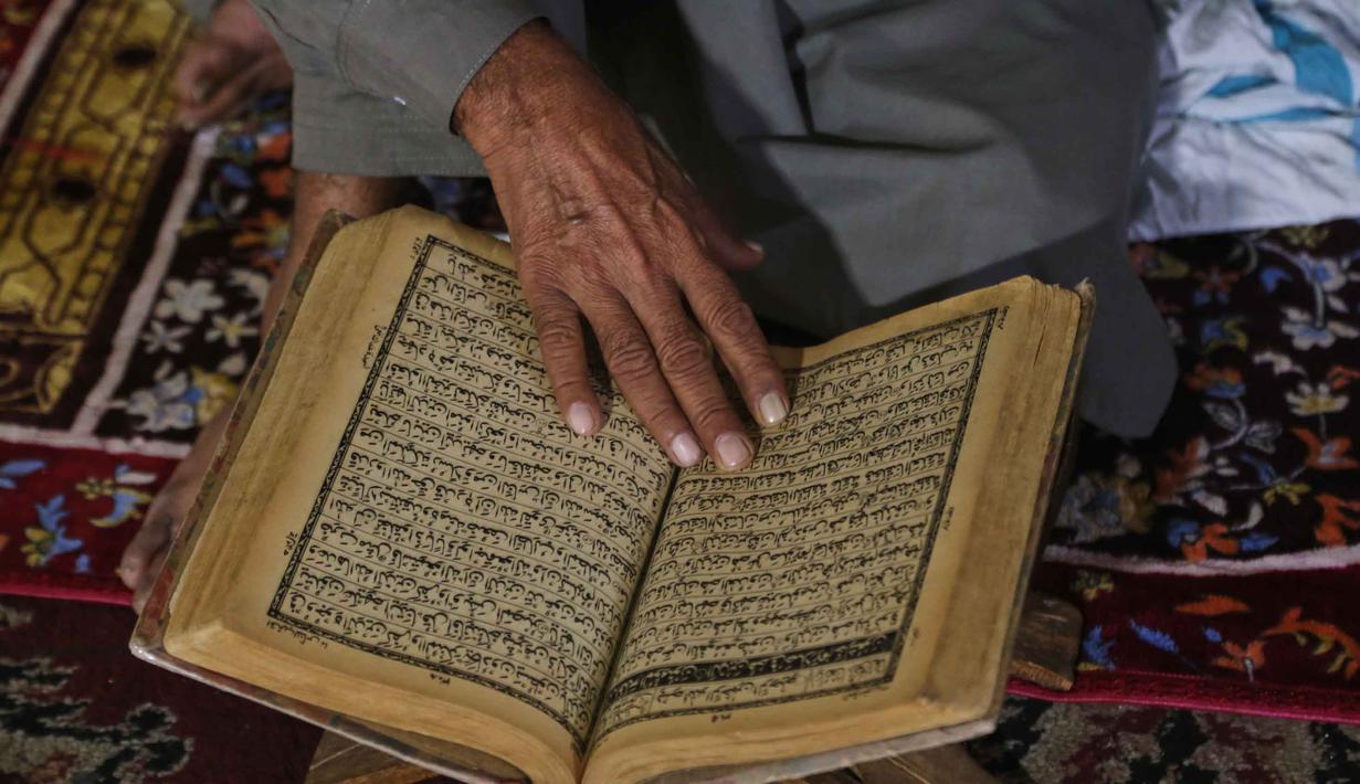 Itikaf dilakukan dengan berdiam diri di dalam masjid disertai amalan seperti salat, dzikir, dan membaca Al Quran. Tampak dalam foto, seorang jamaah Muslim membaca Al Quran saat mereka melaksanakan Itikaf, selama sepuluh hari terakhir bulan Ramadan, di salah satu masjid, di Peshawar, Pakistan, Selasa 10 Maret 2026. (AP Photo/Muhammad Sajjad)