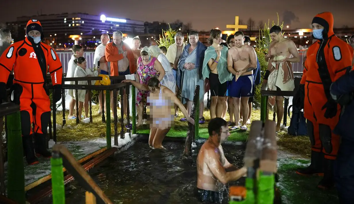 Sejumlah penganut Kristen Ortodoks Rusia mandi dalam air es saat perayaan Epiphany di Gereja Tritunggal Mahakudus, Ostankino, Moskow, Rusia, 18 Januari 2022. Ribuan penganut Kristen Ortodoks Rusia merayakan Epiphany dengan membenamkan diri dalam air dingin. (AP Photo/Alexander Zemlianichenko)