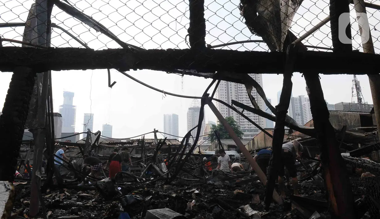 Pedagang mulai mengais sisa barang dagangannya yang habis terbakar yang masih bisa diselamatkan. (merdeka.com/imam buhori)