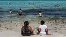 Orang-orang menikmati bermain air di Miami Beach, Florida, Rabu (10/6/2020). Pantai Miami dibuka hari ini untuk pertama kalinya setelah hampir tiga bulan ditutup guna menekan jumlah penyebaran corona Covid-19. (CHANDAN KHANNA / AFP)
