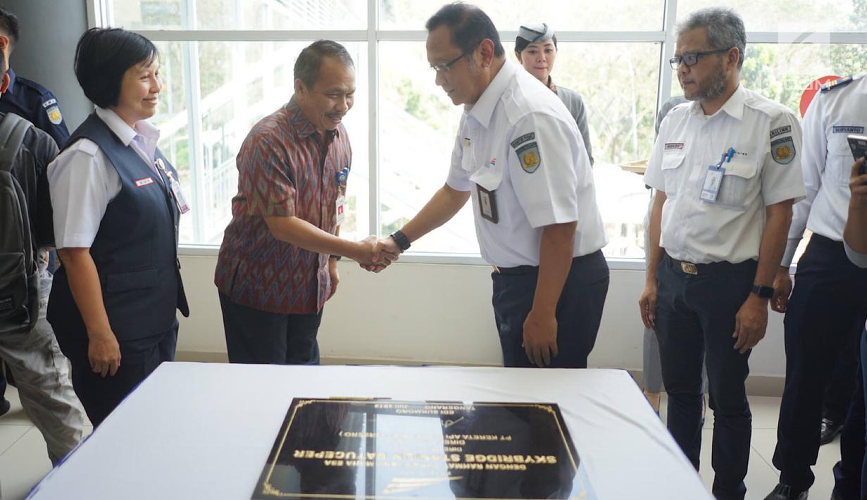 Direktur PT KAI Edi Sukmoro dan Sekda Tangerang Tatang Sutisna bersalaman usai menandatangani batu prasasti peresmian jembatan penghubung atau skybridge antara peron 1-2 (KA Bandara) dengan peron 3-4 (KRL) di Stasiun Batu Ceper, Tangerang, Kamis (18/7/2019). (Liputan6.com/Immanuel Antonius)