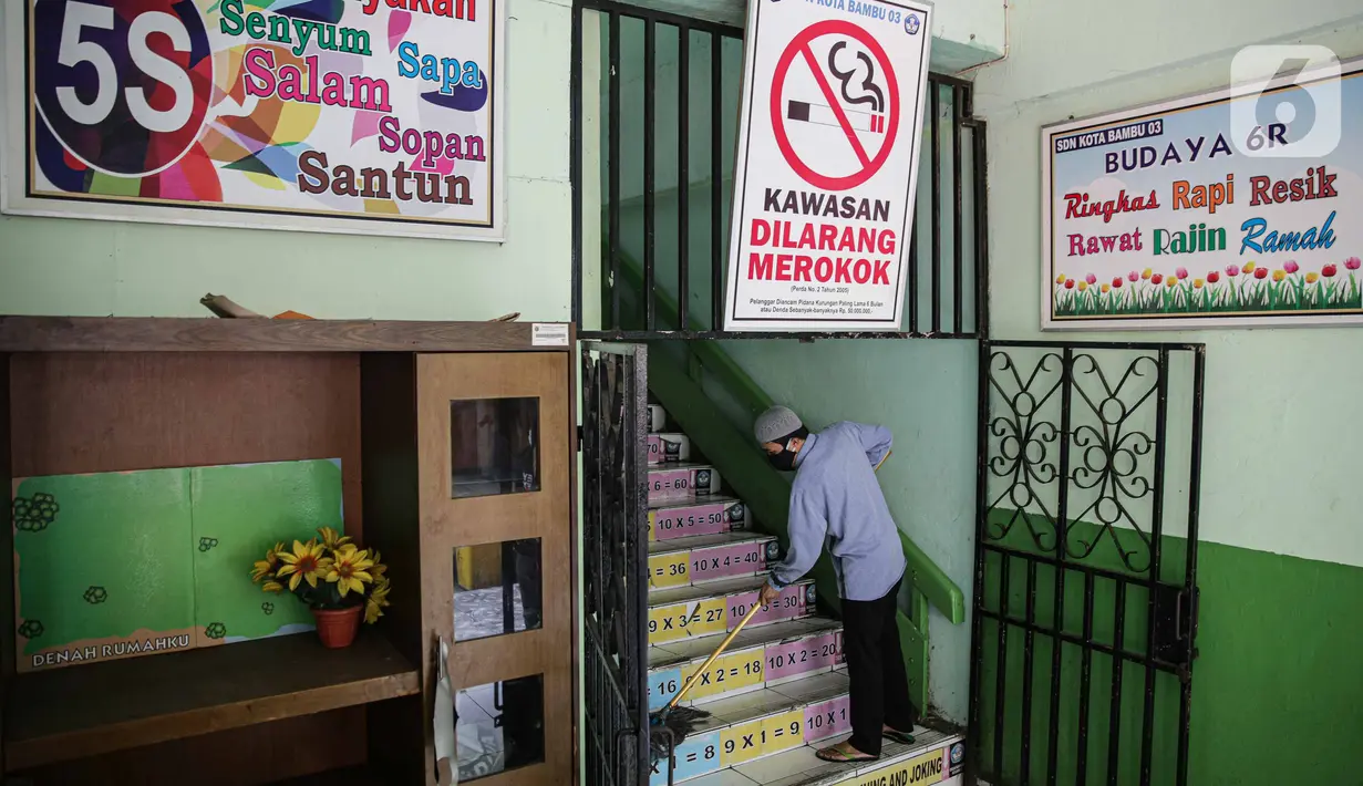 Petugas mengepel lantai tangga di SD Negeri Kota Bambu 03/04, Jakarta, Sabtu (21/11/2020). Pemerintah pusat memberikan kewenangan pemerintah daerah membuka sekolah dan melakukan pembelajaran tatap muka pada semester genap tahun ajaran 2020/2021. (Liputan6.com/Faizal Fanani)