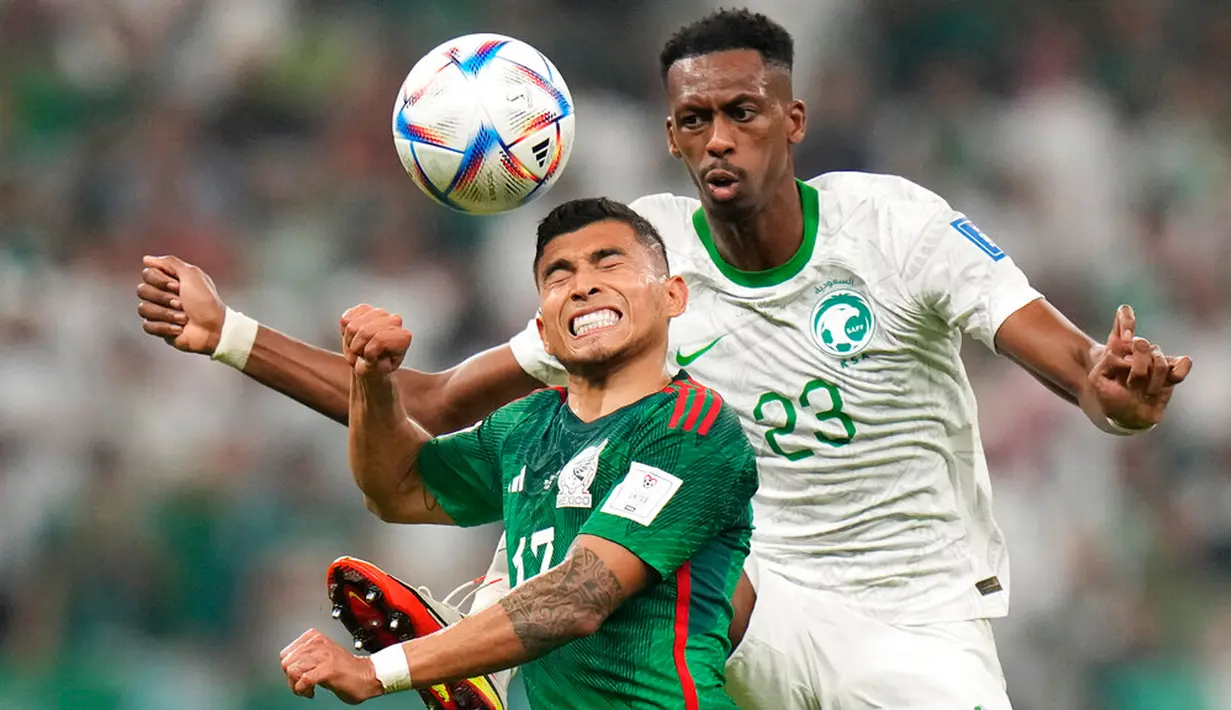Pemain Meksiko Orbelin Pineda (kiri) berebut bola dengan pemain Arab Saudi Mohamed Kanno pada pertandingan sepak bola Grup C Piala Dunia 2022 di Stadion Lusail, Lusail, Qatar, 30 November 2022. Meksiko menang 2-1 tetapi gagal melaju ke babak 16 besar Piala Dunia 2022. (AP Photo/Moises Castillo)