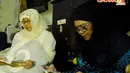 Iin Sina (kiri) mantan istri pertama membacakan doa bersama mantan istri kedua Henny Mariana (kanan) dalam acara 40 Harian Jojon (Liputan6.com/Andrian M Tunay).