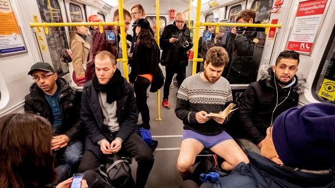 Seorang pria tanpa mengenakan celana membaca buku selama No Pants Subway Ride di sebuah kereta bawah tanah di Berlin, Jerman (13/1). Acara ini dimulai pada tahun 2002 dengan peserta hanya tujuh orang. (AFP Photo/Christoph Soeder)