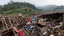 Seorang pria berdiri di dekat reruntuhan rumah saat tim penyelamat mencari korban yang terkubur longsor di Desa Pasirlangu, Cisarua, Kabupaten Bandung, Jawa Barat, pada 26 Januari 2026. Hari ini Selasa 27 Januari 2026, operasi pencarian dan pertolongan korban longsor di Desa Pasirlangu, Cisarua, Kabupaten Bandung, Jawa Barat, kembali dilanjutkan. (Aditya Aji/AFP)