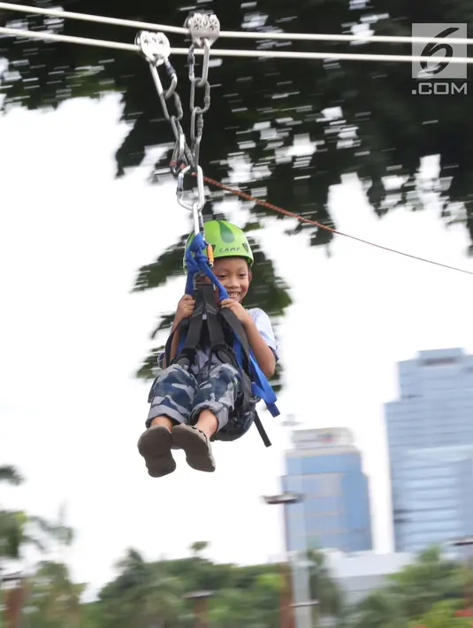 Seorang anak bermain flying fox atau meluncur melalui tali di kawasan Monumen Nasional, Jakarta, Selasa (1/1). Flying Fox gratis ini digelar untuk menambah pelayanan kepada warga yang berlibur di kawasan Monas. (Liputan6.com/Helmi Fithriansyah)