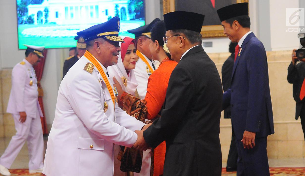 Wakil Presiden Jusuf Kalla (tengah) menyalami Gubernur Maluku Utara Abdul Gani Kasuba saat pelantikan di Istana Negara, Jakarta, Jumat (10/5/2019). Abdul Gani dan Al Yasin merupakan pasangan gubernur-wagub hasil Pilkada Serentak 2018. (Liputan6.com/Angga Yuniar)