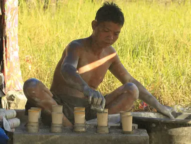 Seorang pekerja menambahkan bubuk mesiu ke dalam silinder karton untuk membuat kembang api di dalam pondok di kota Bocaue, provinsi Bulacan, Filipina, (26/12/2015) Desember 2015. (REUTERS/Romeo Ranoco)