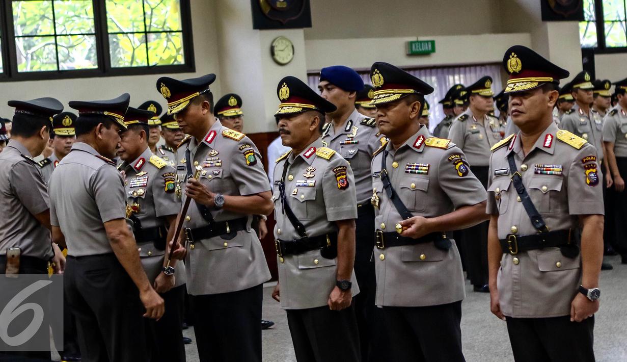 Kapolri Jend. (Pol.) Badrodin Haiti memberikan tongkat komando kepada Kapolda Metro Jaya yang baru, Irjen Moechgiyarto saat sertijab Kapolda di Rupatama, Mabes Polri, Jakarta, (21/3). Moechgiyarto  mengantikan Tito Karnavian. (Liputan6.com/Fery Pradolo)