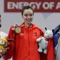 Atlet Wushu Indonesia, Lindswell Kwok (tengah) foto bersama denga atlet wushu Hongkong, Mok Uen Ying (kiri) dan atlet wushu Filipina Agatha Wong setelah pemberian medali pada Asian Games ke-18 di Jakarta, (20/8). (AP Photo/Aaron Favila)