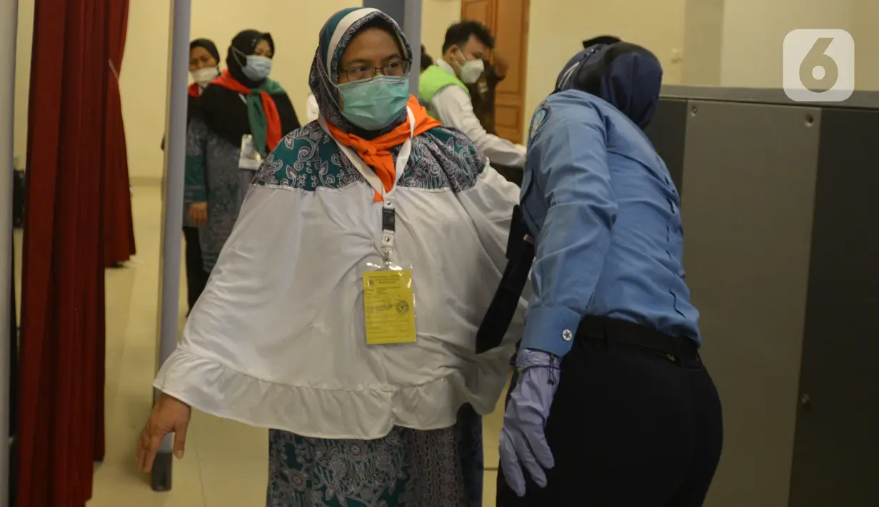 Petugas memeriksa jemaah calon haji kelompok terbang (kloter) 1 embarkasi haji Jakarta - Pondok Gede di Asrama Haji Pondok Gede, Jakarta, Sabtu (4/6/2022) dini hari. Sebanyak 389 calon haji asal DKI Jakarta yang tergabung dalam kloter 1 embarkasi haji Jakarta - Pondok Gede diberangkatkan menuju tanah suci Arab Saudi melalui Bandara Internasional Soekarno - Hatta. (merdeka.com/Imam Buhori)